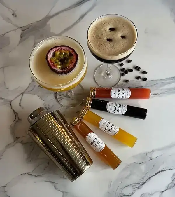 Afbeelding van een passievruchtcocktail en een Espresso Martini, met cocktailingrediënten in kleine buisjes en een cocktailshaker.