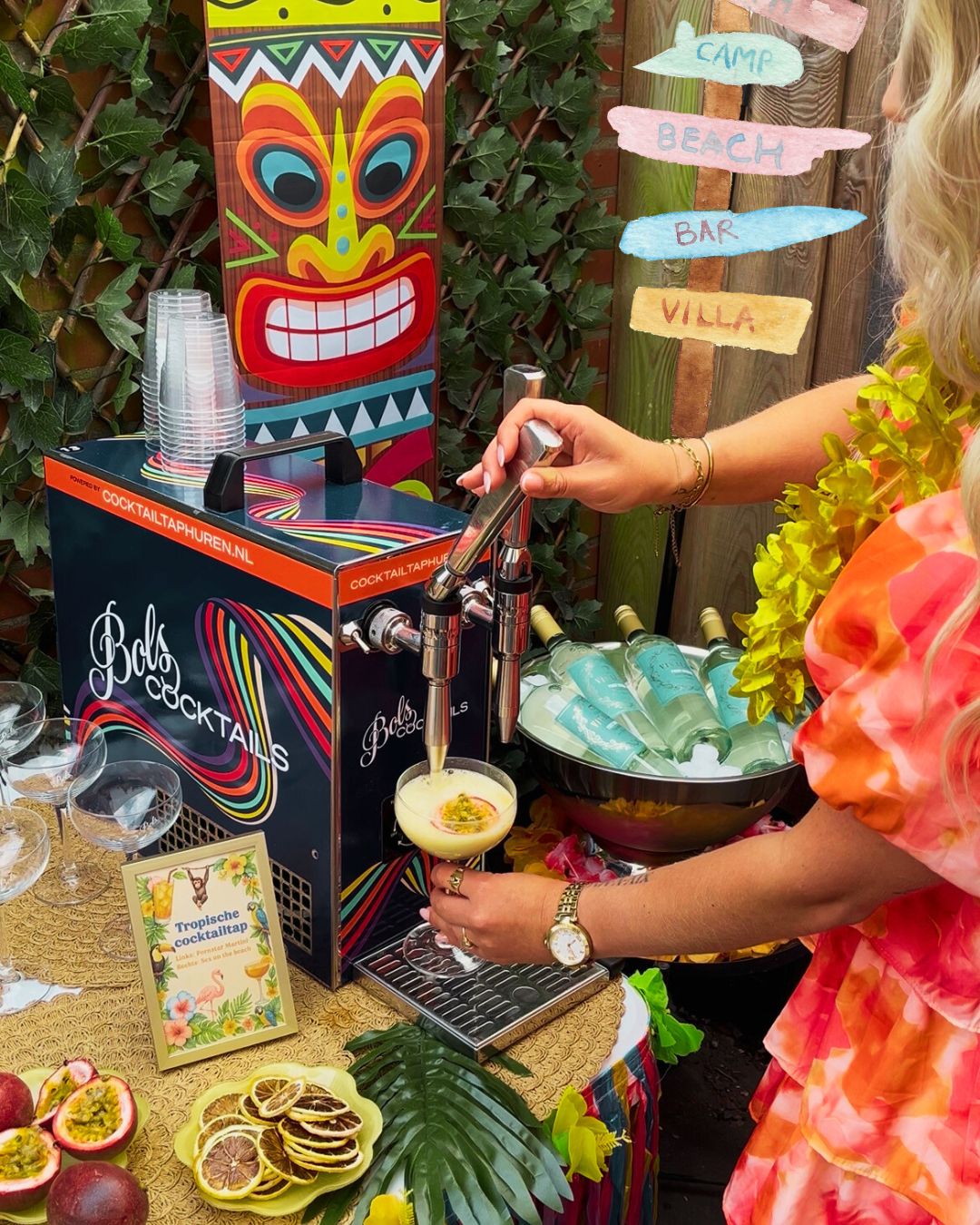 Twee handen die cocktails tappen uit een blauwe cocktailtap van Bols Cocktails. De cocktailtap heeft twee tappen en het logo van Bols Cocktails. Op de achtergrond is een schilderij van een cocktail te zien.
